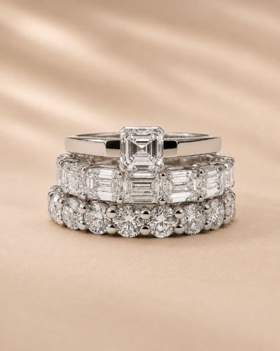Stack of three lab grown diamond rings featuring an emerald cut center and eternity bands