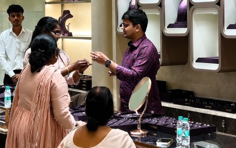Customers browsing lab grown diamond jewelry at a luxury jewelry store.