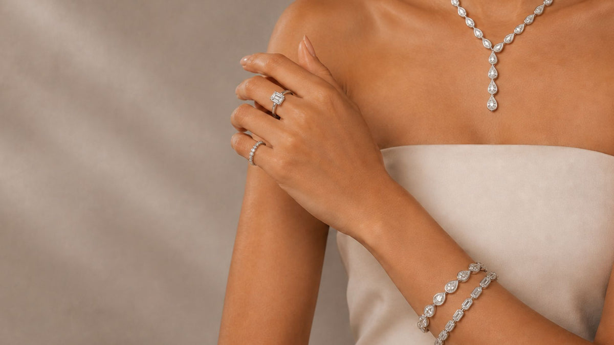 Woman wearing lab grown diamond rings, pear-shaped diamond necklace, and bracelets.